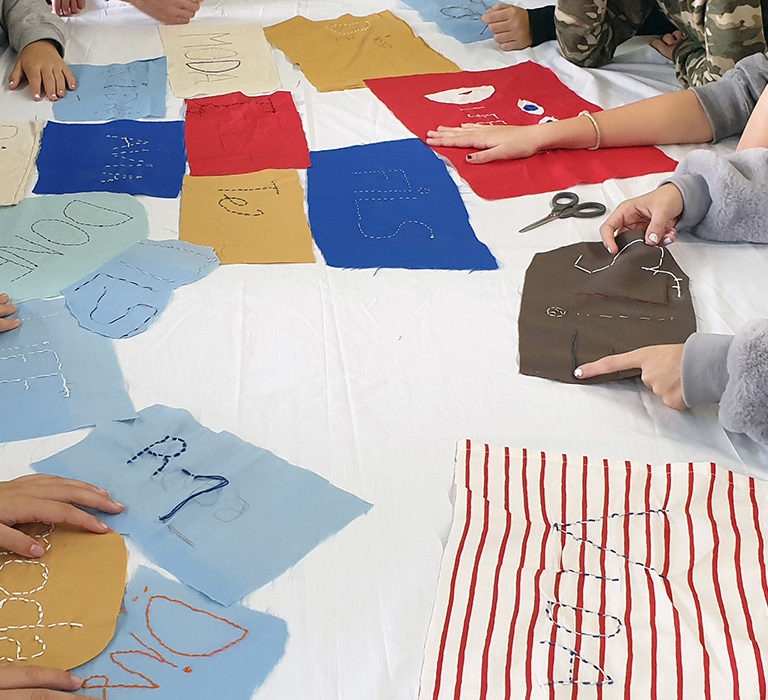 Alumnos bordando palabras relacionadas con el textil